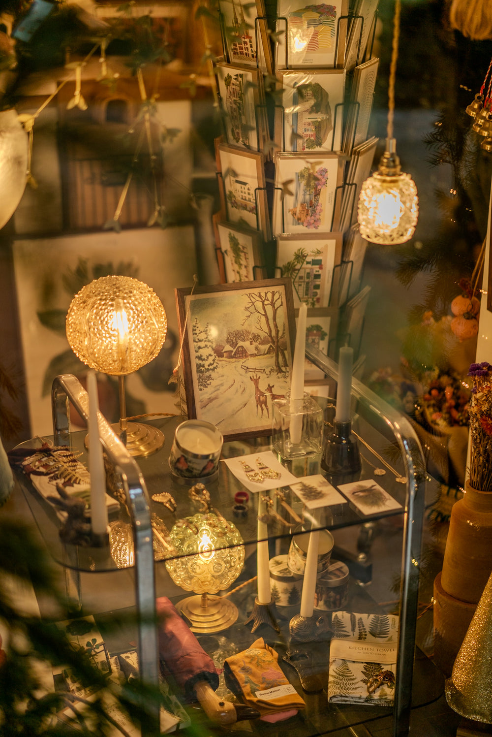 La vitrine de la boutique allume-moi à la nuit tombée, luminaires allumés